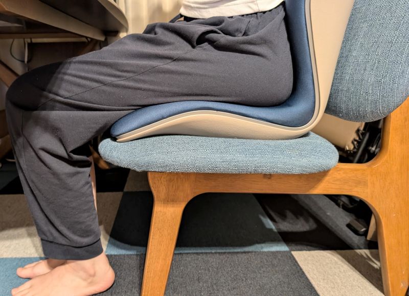 ダイニングチェアにスタイルプレミアムを置いて座る様子